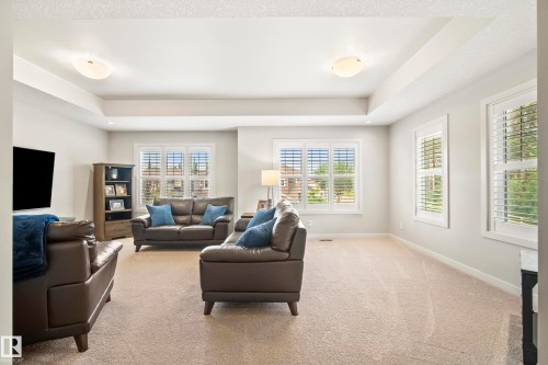 Spacious living area featuring a tray ceiling with recessed lighting and two semi-flush mount fixtures - 5966 Edmonds Crescent Nw, Edmonton, AB - Indoor Photo Showing Living Room
