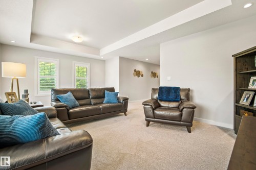 Spacious living area featuring light gray walls, plush carpet flooring, and a recessed tray ceiling - 5966 Edmonds Crescent Nw, Edmonton, AB - Indoor Photo Showing Living Room