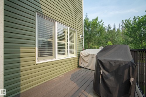 Exterior balcony featuring wood-finish decking and a black metal railing - 5966 Edmonds Crescent Nw, Edmonton, AB - Outdoor With Deck Patio Veranda With Exterior