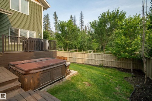 Expansive backyard featuring a manicured lawn, established trees, and a full privacy fence - 5966 Edmonds Crescent Nw, Edmonton, AB - Outdoor With Deck Patio Veranda
