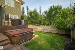 Expansive backyard featuring a manicured lawn, established trees, and a full privacy fence - 
