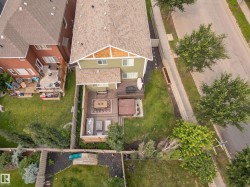 Terraced backyard featuring an upper-level deck, ground-level patio, and built-in hot tub - 