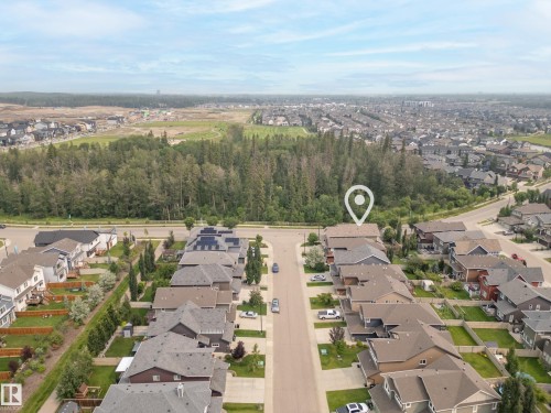 Aerial perspective showcasing a residential development with a forested backdrop - 5966 Edmonds Crescent Nw, Edmonton, AB - Outdoor With View
