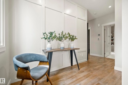 Hallway featuring light wood-finish flooring, white paneled wall detailing, and recessed lighting - 5966 Edmonds Crescent Nw, Edmonton, AB - Indoor Photo Showing Other Room