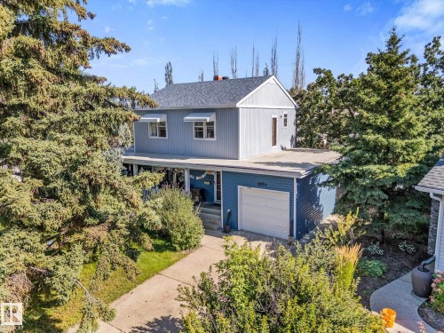 Residential structure with light blue siding, an attached garage, a front porch, and a paved driveway - 6054 107A Street Nw, Edmonton, AB 