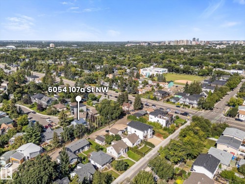 Aerial perspective of a developed neighborhood with mature trees and a distant city skyline - 6054 107A Street Nw, Edmonton, AB 