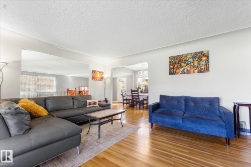 Hardwood flooring throughout, recessed archway, and neutral wall paint - 6054 107A Street Nw, Edmonton, AB 