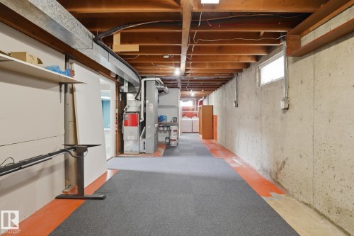 Exposed wood joists, concrete foundation walls, and a small window provide natural light - 13304 63 Street Nw, Edmonton, AB 