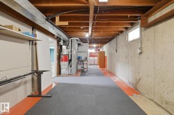Exposed wood joists, concrete foundation walls, and a small window provide natural light - 