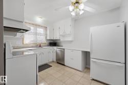 Kitchen featuring white cabinetry, a built-in dishwasher, tile flooring, and a ceiling fan with integrated lighting - 