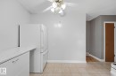 White refrigerator with an overhead ceiling fan - 13304 63 Street Nw, Edmonton, AB 