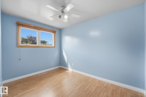Wood-finish flooring, an overhead ceiling fan, and a double window with wood trim - 13304 63 Street Nw, Edmonton, AB 