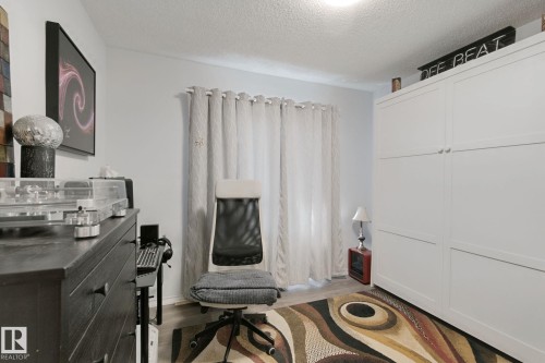 Light-toned walls with a window featuring privacy curtains, and wood-finish flooring - 12035 83 Street Nw, Edmonton, AB 