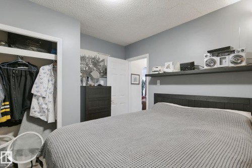 Recessed closet, built-in shelving, wood-finish headboard, light gray wall paint, and white trim - 12035 83 Street Nw, Edmonton, AB 
