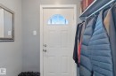 Entry door with a decorative arched transom window and a built-in storage shelf with hanging rod - 12035 83 Street Nw, Edmonton, AB 