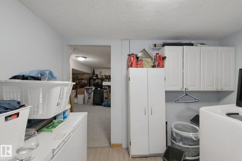 White cabinetry, white storage cabinet, and vinyl plank flooring - 12035 83 Street Nw, Edmonton, AB 