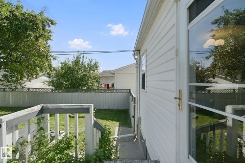 White vinyl siding exterior with a clear storm door and a fenced backyard - 12035 83 Street Nw, Edmonton, AB 