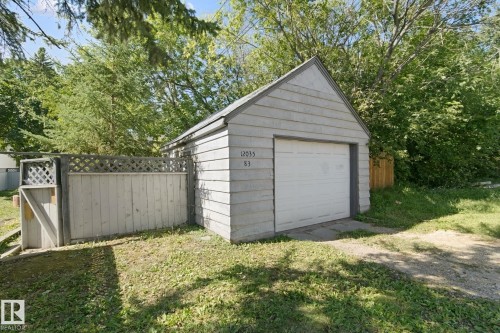 Detached garage with horizontal siding, a pitched roof, and a white overhead door - 12035 83 Street Nw, Edmonton, AB 