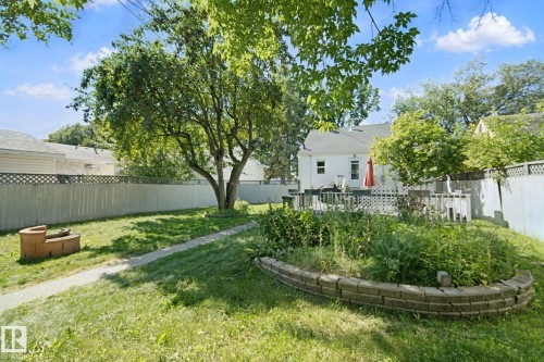 Expansive backyard featuring a manicured lawn, established landscaping, privacy fencing, and a multi-level deck - 12035 83 Street Nw, Edmonton, AB 
