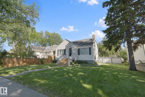 Light-colored siding exterior with dark shutters, gabled roof, and a prominent chimney - 12035 83 Street Nw, Edmonton, AB 