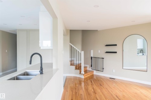 Kitchen island with a double basin stainless steel sink and matte black faucet - 5010 147 Street Nw, Edmonton, AB 
