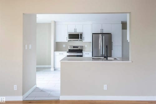 Modern kitchen with white cabinetry and stainless steel appliances - 5010 147 Street Nw, Edmonton, AB 
