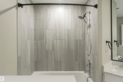 Bathtub and shower combination featuring large format tile surround - 