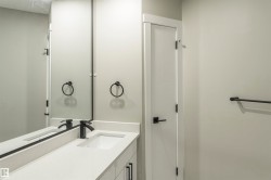 Contemporary bathroom vanity featuring a rectangular undermount sink, light-toned countertop, and matte black faucet - 