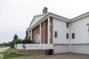 Brick and white siding exterior featuring a columned portico, gable roofline, and attached two-car garage - 5010 147 Street Nw, Edmonton, AB 