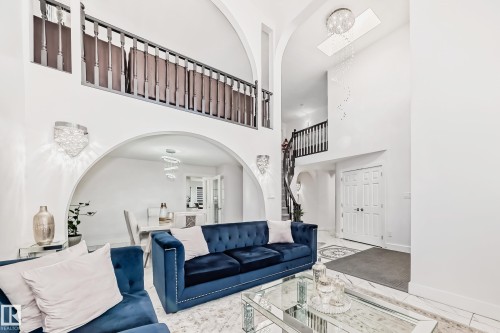Two-story foyer with high ceilings, arched doorways, an upper-level balcony, and a grand staircase - 4608 43 Avenue Nw, Edmonton, AB 