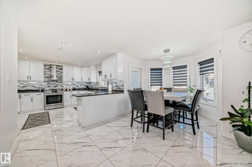 White gloss cabinetry, stainless steel appliances, dark countertops, and large format tile flooring - 4608 43 Avenue Nw, Edmonton, AB 