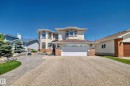 Two-story exterior with multi-pane arched windows, attached garage, exposed aggregate driveway, and paved walkway - 4608 43 Avenue Nw, Edmonton, AB 