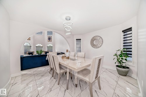 Archway opening, large format marble-look tile flooring, contemporary chandelier, multiple windows with blinds, recessed lighting - 4608 43 Avenue Nw, Edmonton, AB 
