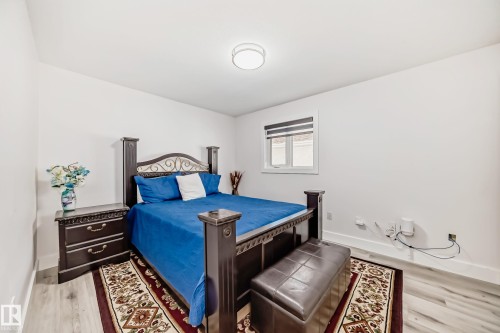 Recessed window with horizontal blinds, wood-finish flooring, and overhead flush-mount lighting fixture - 4608 43 Avenue Nw, Edmonton, AB 