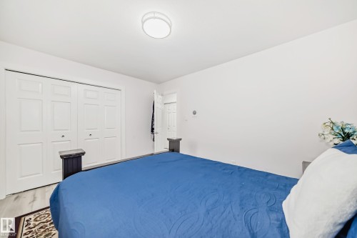 Recessed ceiling light fixture, wood-finish flooring, and white bi-fold closet doors - 4608 43 Avenue Nw, Edmonton, AB 
