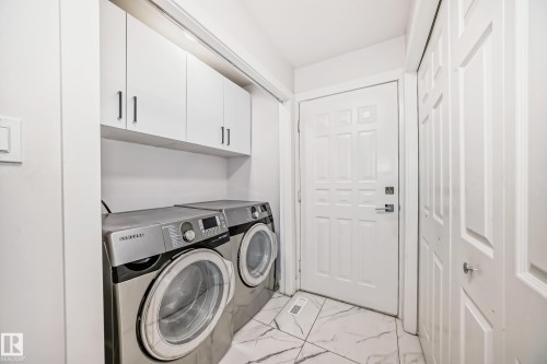 Laundry area featuring white cabinetry, built-in shelving, and light-toned tile flooring - 4608 43 Avenue Nw, Edmonton, AB 