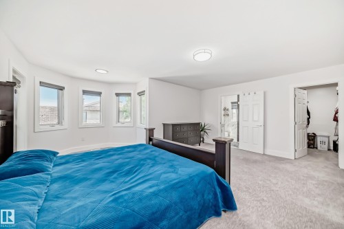 Expansive room featuring light-colored carpeting, multiple windows with roller shades, and white walls - 4608 43 Avenue Nw, Edmonton, AB 