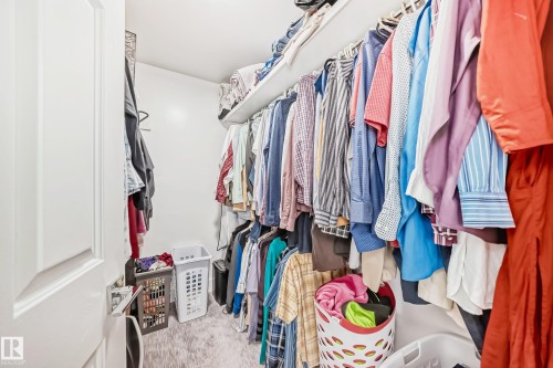 Walk-in closet with white walls, built-in shelving, and hanging rods - 4608 43 Avenue Nw, Edmonton, AB 