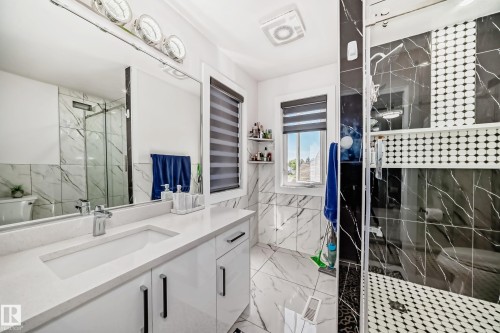 White high-gloss vanity with an integrated rectangular sink and chrome faucet - 4608 43 Avenue Nw, Edmonton, AB 