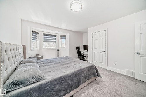 Recessed bay window, neutral carpeting, white interior doors, and a built-in desk area - 4608 43 Avenue Nw, Edmonton, AB 