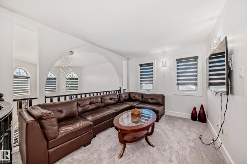 Loft area featuring an arched entryway, decorative railing, and patterned window treatments - 4608 43 Avenue Nw, Edmonton, AB 