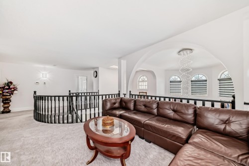 Archway with a chandelier, arched windows with horizontal blinds, and a black baluster railing - 4608 43 Avenue Nw, Edmonton, AB 