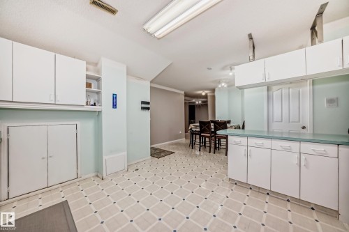 White cabinetry, patterned flooring, and recessed lighting - 4608 43 Avenue Nw, Edmonton, AB 