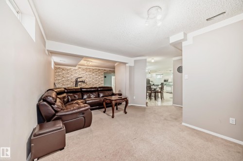 Recessed ceiling lighting, textured ceiling, light-colored carpeting, window well, and neutral wall tones - 4608 43 Avenue Nw, Edmonton, AB 
