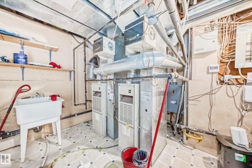 Utility area featuring two furnaces, a water heater, and a utility sink - 4608 43 Avenue Nw, Edmonton, AB 