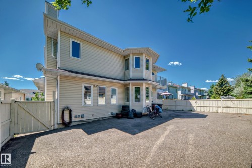 Siding exterior featuring multiple windows, a bay window, and an upper-level balcony with glass railing - 4608 43 Avenue Nw, Edmonton, AB 