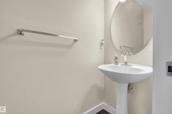 Pedestal sink with polished chrome faucet and round wall mirror - 