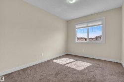 Room featuring a multi-pane window with white trim, neutral-toned walls, and brown carpeting - 