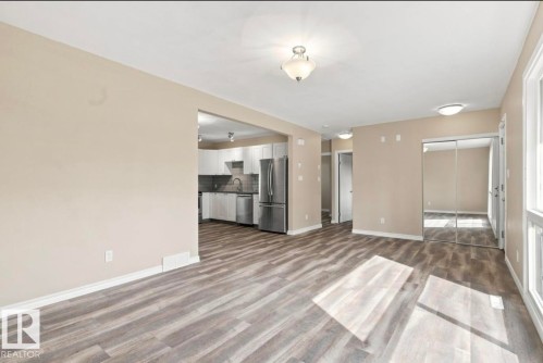 Wood-finish flooring throughout, modern kitchen with stainless steel appliances, recessed lighting, and mirrored closet doors - 15812 110A Avenue Nw, Edmonton, AB 
