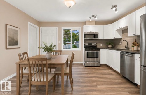 White cabinetry with stainless steel appliances and dark countertops - 15812 110A Avenue Nw, Edmonton, AB 